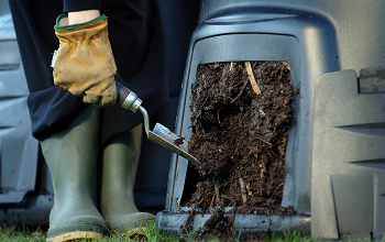 Lovely brown compost being emptied from a green compost bin.