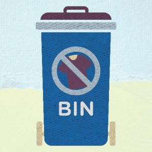 Image of a blue wheelie bin with a circle on the front. The circle has got an image of a t-shirt in the centre and has a line diagonally across from top left to bottom right, to imply textiles are prohibited in the bin. 