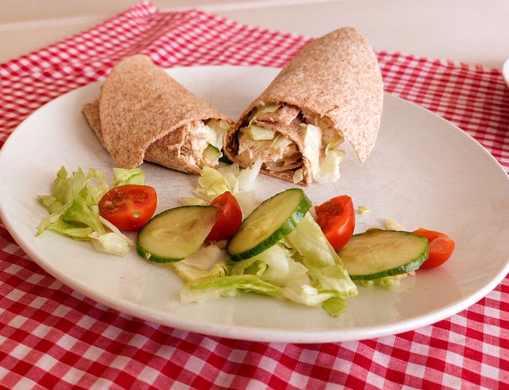 Spicy chicken and salad wrap with a side salad