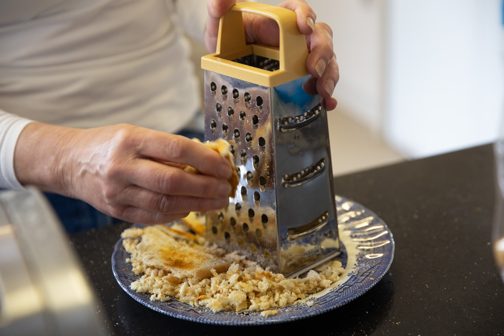 Person grating a piece of toast