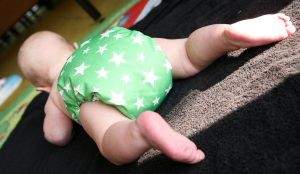 A baby crawling and wearing a reusable nappy