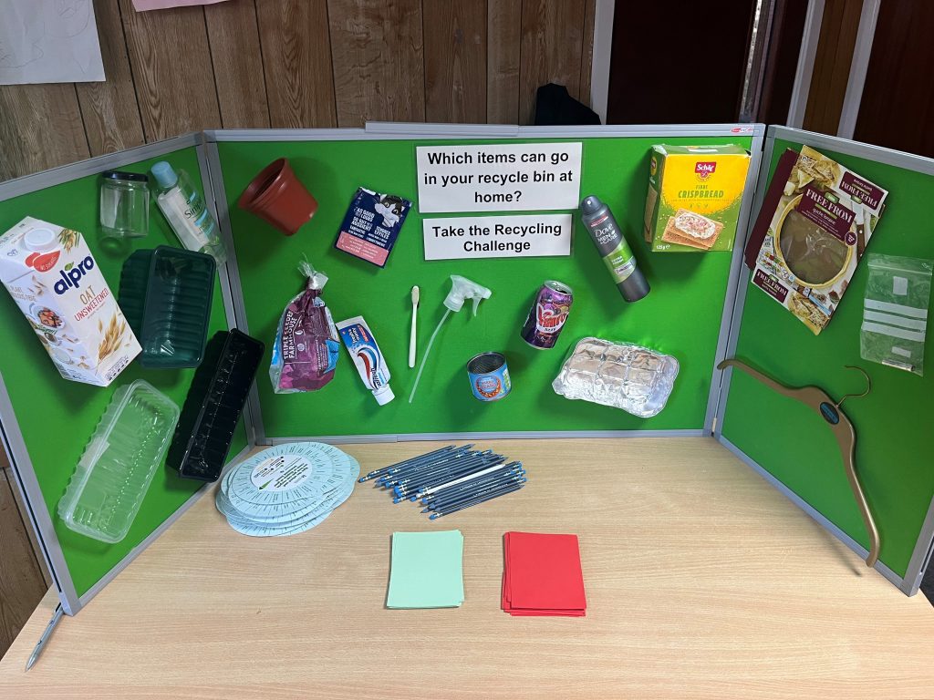 Green display board with different packaging materials on it.